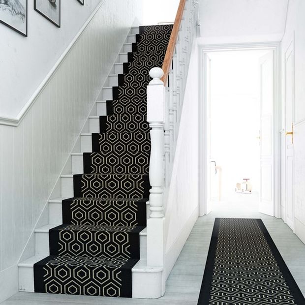 Staircase with white railings and black stair runner