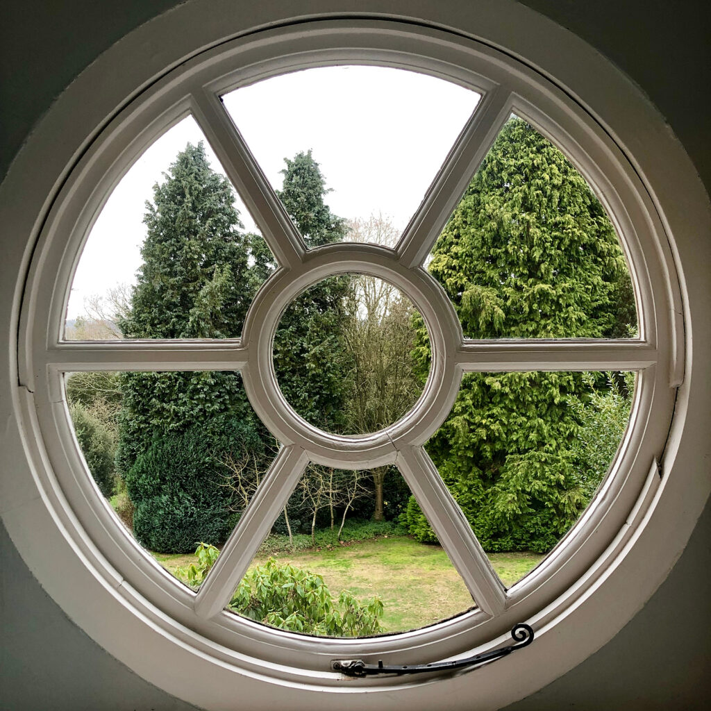 Circular port hole window view into garden