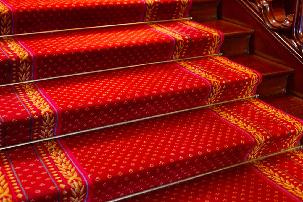 Red Victorian carpet, on a mahogany staircase