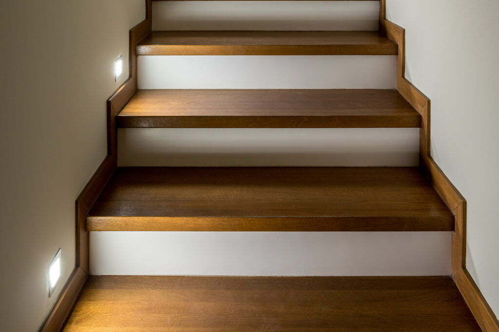 Illuminated staircase with wooden steps and white risers